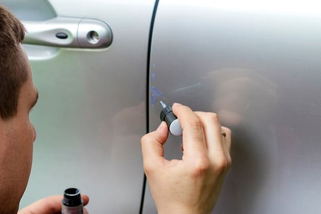 A close-up of a hand carefully applying touch-up paint to a small paint chip on a car door using a fine-tipped brush, with focus on the precise application technique.