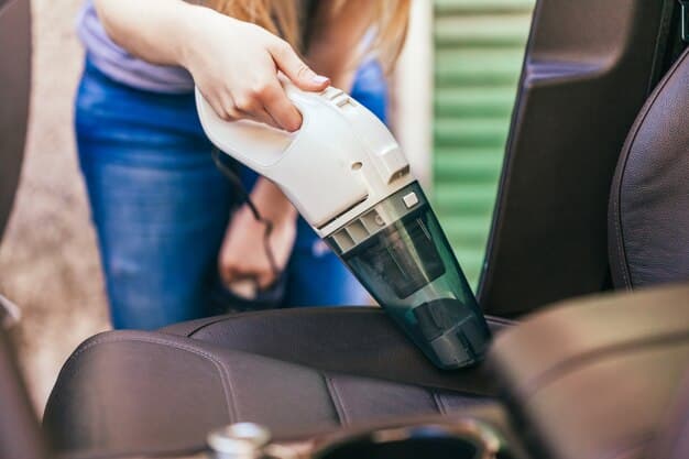 A person sprinkling baking soda on a car seat to absorb odors, with a vacuum cleaner nearby.
