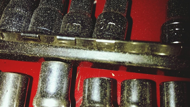 A close-up shot of a dirty engine component covered in grime and oil, highlighting the need for engine bay detailing.