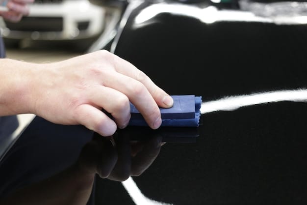 A person using detailing clay on a car door, showing the clay picking up contaminants and leaving a smooth, clean surface ready for scratch removal compound application.