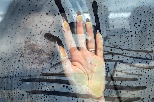 A close-up of a person's hand running over a car's paint surface, illustrating the process of feeling for contaminants before using a clay bar. The area is well-lit to show the texture of the paint.