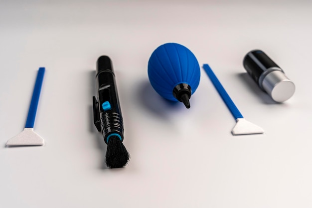 Close-up of various PPF installation tools laid out on a clean surface, including a squeegee, microfiber cloths, spray bottle with soapy water, heat gun, and trimming knife. The tools are arranged in an orderly fashion, suggesting careful preparation.