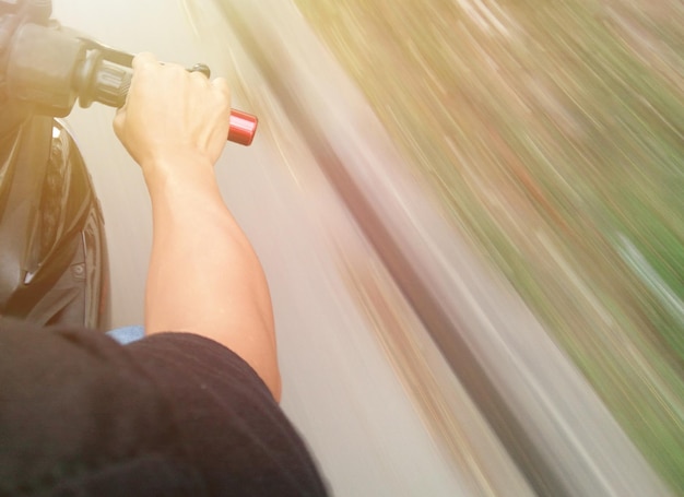 A person using a heat gun to shrink and conform window tint film to the curved surface of a car window.