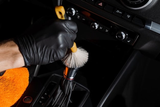 Close-up of a car's interior being meticulously cleaned with specialized brushes and cleaning solutions. Focus is on the dashboard and center console area, showcasing the attention to detail.