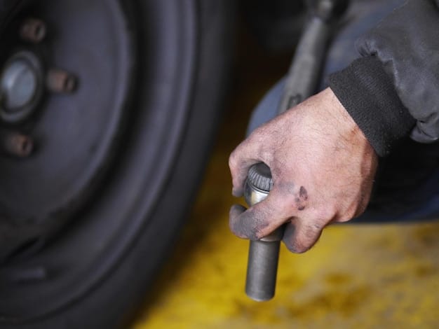 A close-up of a mechanic inspecting a tire tread with precision tools in a well-lit service bay, emphasizing the importance of professional tire inspection.