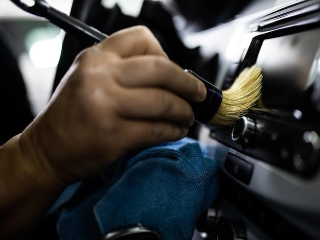 A close-up shot of a car's paint surface being professionally polished, with a technician's hands visible. The paint is gleaming and reflective.