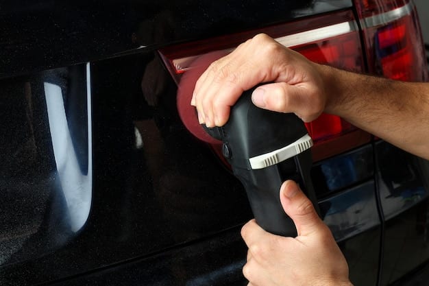 A close-up of a technician applying a protective film to a car door. The lighting is bright, showcasing the application process and the smoothness of the film. The focus is on the technician's hand and the area of application on the car door.