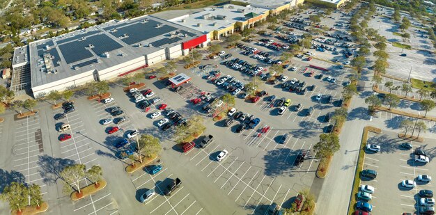 A photo of a car dealership with very few cars on the lot, with a sign indicating extended wait times for new vehicle orders. The overall tone of the image should be slightly concerning, reflecting the consumer's perspective.