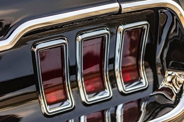 Close-up shot of the 2026 Ford Mustang's redesigned taillights, showing the three-bar design with a modern LED lighting signature. The car is painted in a dark gray color.
