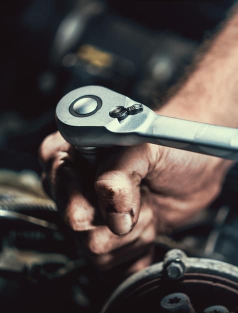 A close-up shot of a mechanic's hands working on a car engine. The mechanic is using a wrench to tighten a bolt, and the engine is partially disassembled. The lighting is focused on the engine compartment, highlighting the complexity of the repair work.