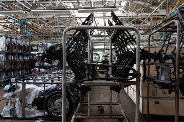 An image showing a car factory with various components and raw materials stacked, highlighting the rising costs of production.