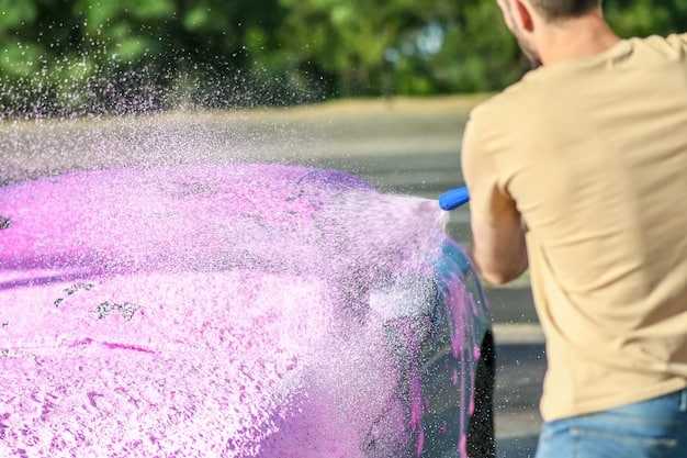 A person using a foam cannon to apply pH-neutral soap to a ceramic coated car, ensuring even coverage and gentle cleaning.