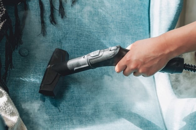 A person using a handheld steam cleaner on a car seat, demonstrating the focused application of steam to lift stains and dirt from the upholstery, with steam visibly rising from the fabric.