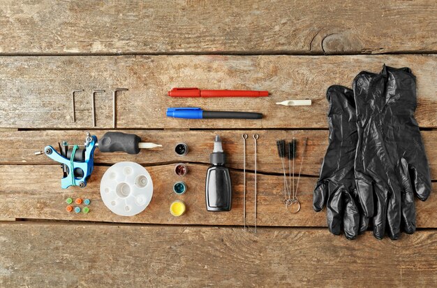 A collection of engine detailing tools neatly arranged on a workbench, including various brushes, microfiber cloths, degreasers, plastic protectants, and safety gear like gloves and eye protection.