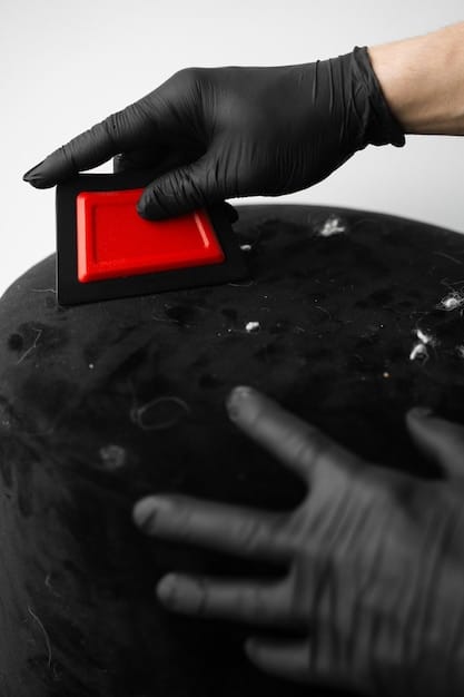 Close-up of a hand gently gliding a clay bar over a car's hood, showing the smooth, decontaminated surface of the paint ready for waxing.