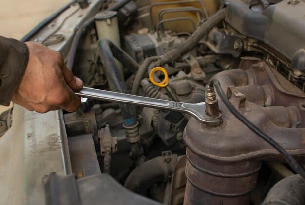 A mechanic using a torque wrench to tighten a spark plug in an engine bay. The focus is on proper technique and the use of the torque wrench.