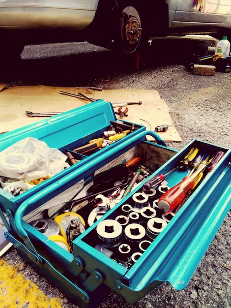 A well-organized toolbox containing various car dent repair tools, including a dent puller kit, rubber mallet, heat gun, and a slide hammer. The tools are clean and neatly arranged.