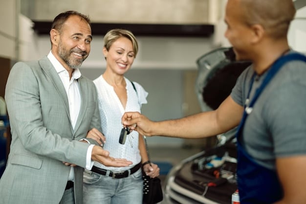 A cheerful service advisor handing car keys to a smiling customer in a well-lit service center. In the background, a sign reads: 