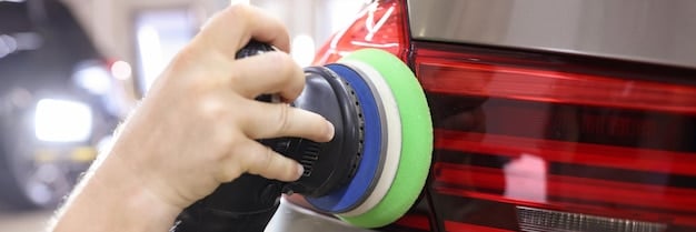 A close-up shot of a dual-action polisher being used on a car's hood. The polisher is equipped with a polishing pad, and there's a clear separation of the corrected paint versus the uncorrected paint. The lighting highlights the swirl marks being removed by the polisher.