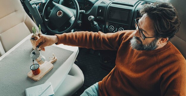 A person using a detailing brush to clean the interior of a car, focusing on the dashboard and center console. The image highlights the attention to detail and the tools used for effective interior cleaning. Demonstrating one aspect of The Latest Car Detailing Trends: What's New and What's Worth Trying in 2025, which includes specialized tools for thorough cleaning.