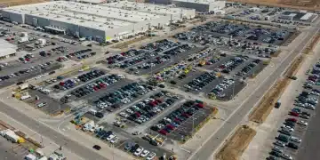 Modern automotive factory with electric vehicles on an assembly line, representing new US manufacturing investments.