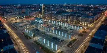 Modern city skyline at dusk with illuminated EV charging stations
