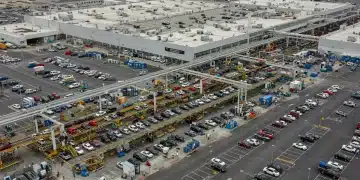 Aerial view of a large, modern US automotive plant, symbolizing job growth and economic expansion.